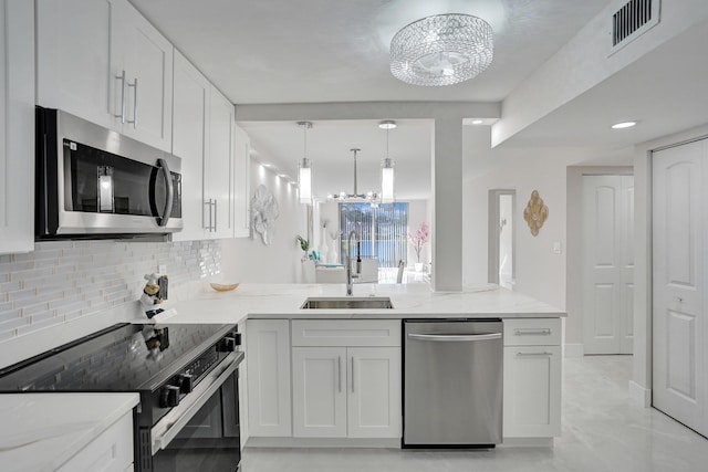 kitchen with visible vents, tasteful backsplash, a sink, appliances with stainless steel finishes, and a notable chandelier