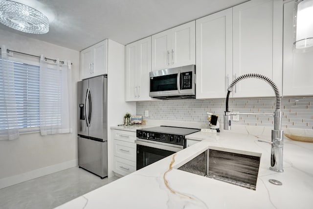 kitchen with light stone countertops, white cabinets, and appliances with stainless steel finishes