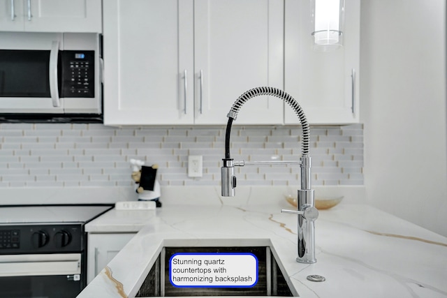 kitchen with white cabinetry, light stone countertops, and electric stove