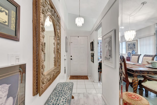 foyer with vaulted ceiling, light tile patterned floors, and a chandelier