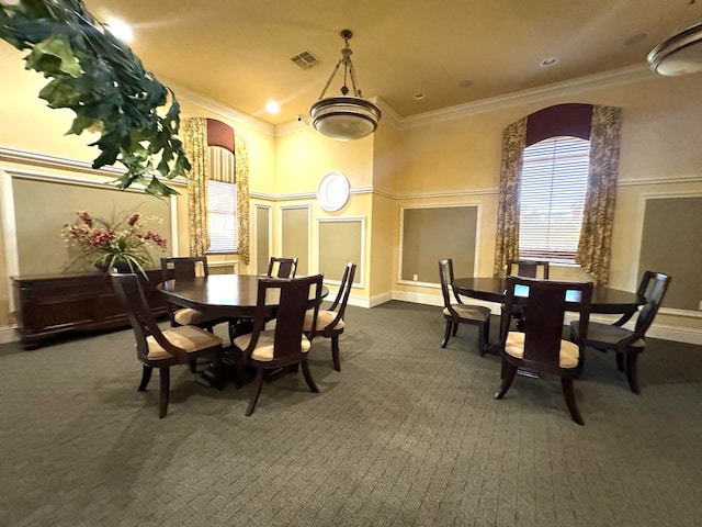 dining room with dark colored carpet and crown molding