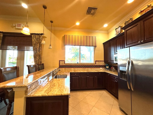 kitchen with stainless steel fridge, backsplash, ornamental molding, sink, and a breakfast bar area