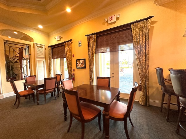 dining room with dark carpet, crown molding, and french doors