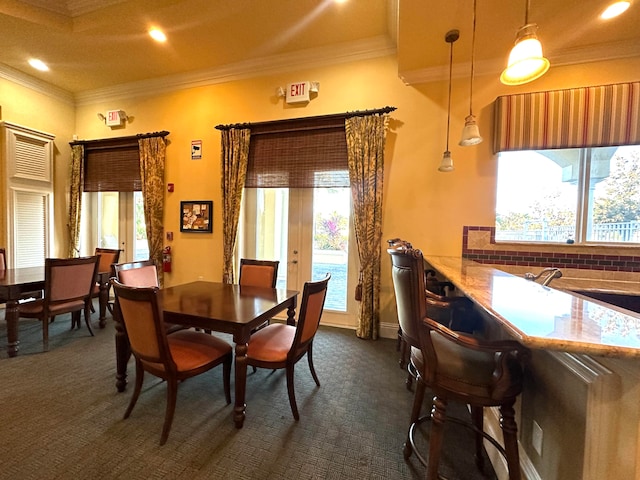 carpeted dining area featuring crown molding, french doors, and a healthy amount of sunlight