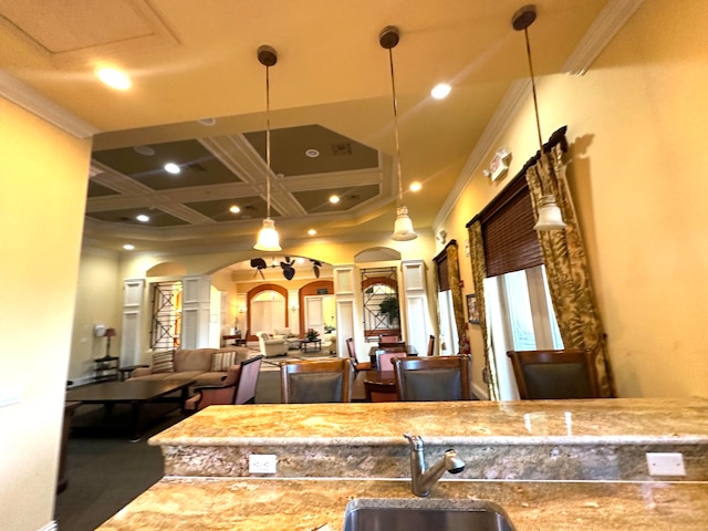 interior space with decorative light fixtures, crown molding, coffered ceiling, and sink