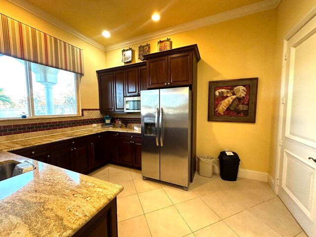 kitchen with decorative backsplash, crown molding, dark brown cabinetry, and stainless steel appliances