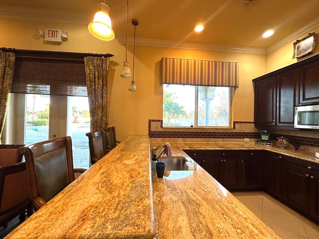 kitchen featuring sink, light stone counters, backsplash, crown molding, and light tile patterned floors