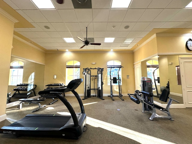 workout area featuring a paneled ceiling, ceiling fan, and ornamental molding