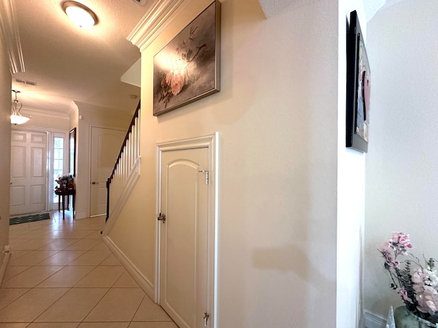 corridor with a textured ceiling and light tile patterned flooring