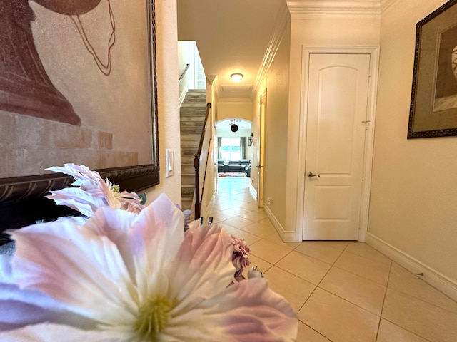 hallway featuring light tile patterned floors and crown molding