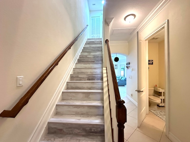 staircase with tile patterned flooring and ornamental molding