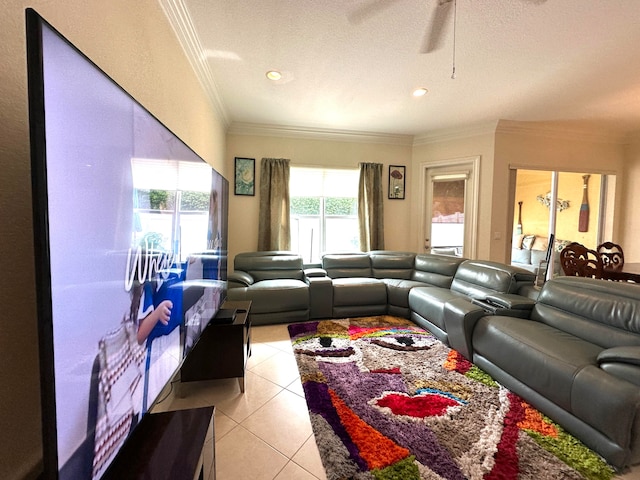 tiled living room with a textured ceiling, ceiling fan, and ornamental molding