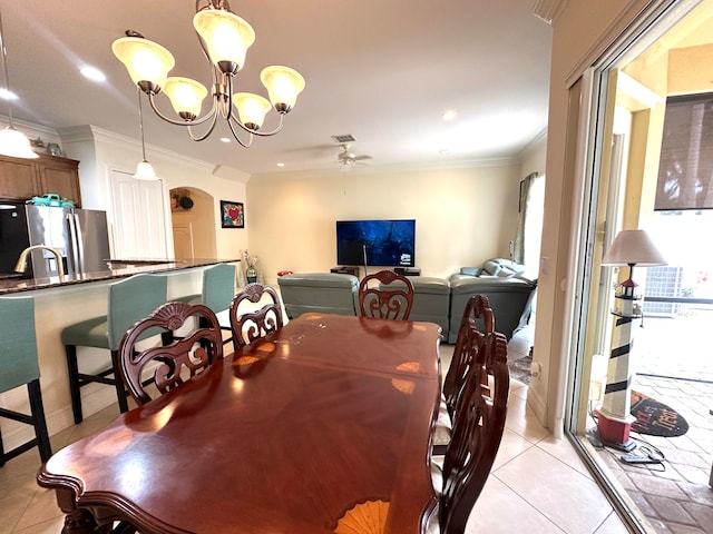 tiled dining area featuring ceiling fan with notable chandelier and crown molding