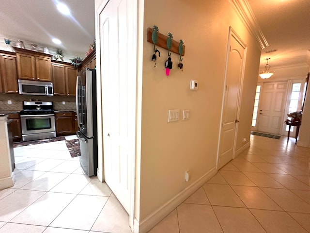 hallway featuring light tile patterned floors and ornamental molding