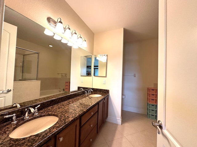 bathroom featuring a tub to relax in, tile patterned flooring, vanity, and a textured ceiling