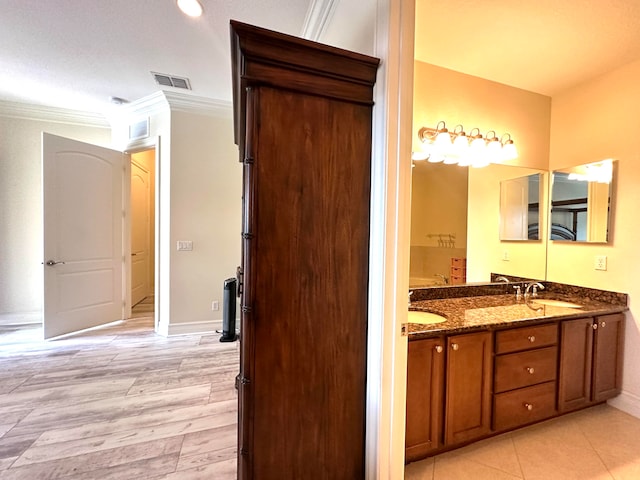 bathroom featuring hardwood / wood-style floors, vanity, and ornamental molding