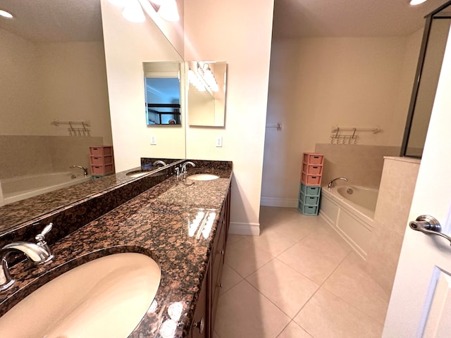 bathroom with tile patterned floors, vanity, and a tub to relax in