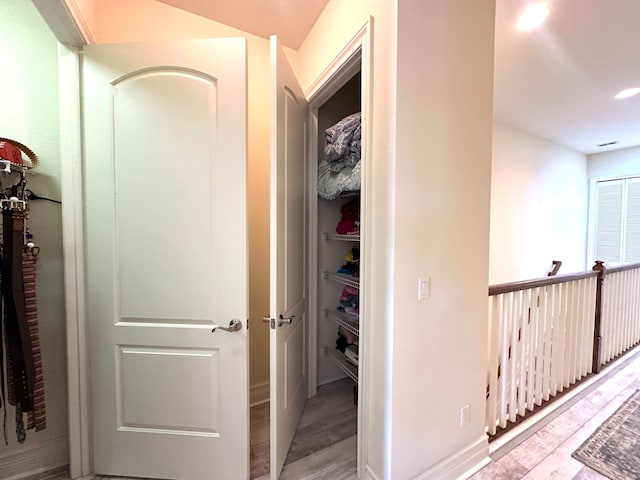 corridor with light hardwood / wood-style floors