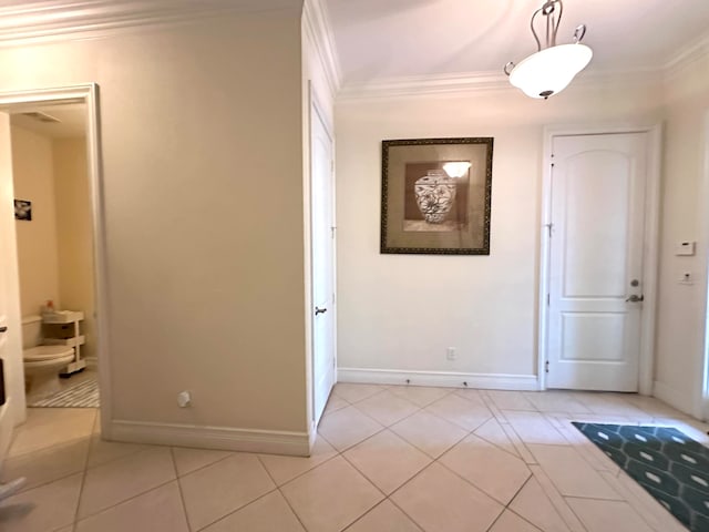 hallway with ornamental molding and light tile patterned flooring