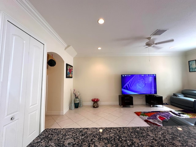 tiled living room with ceiling fan and crown molding