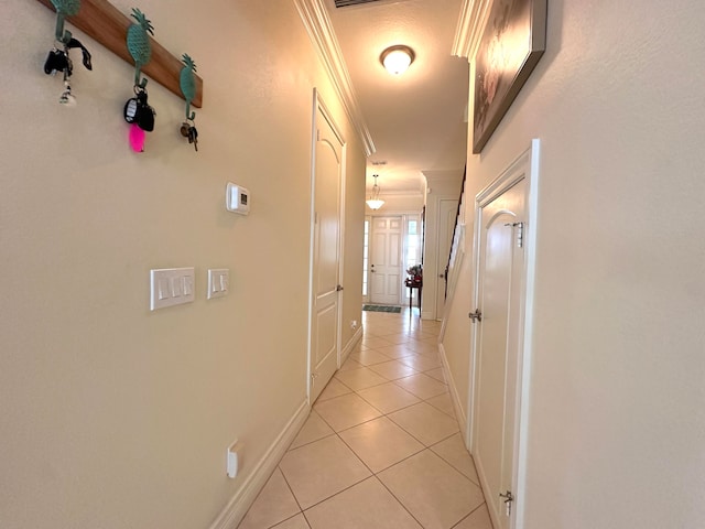 corridor featuring light tile patterned floors and ornamental molding