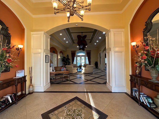 entryway featuring a notable chandelier, ornamental molding, light tile patterned floors, and french doors