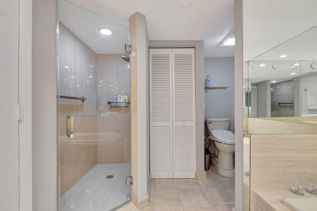 bathroom featuring tile patterned flooring, toilet, and walk in shower