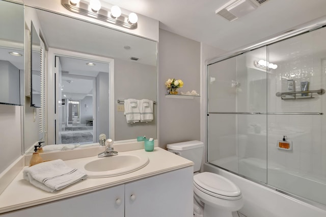 full bathroom with vanity, toilet, and shower / bath combination with glass door