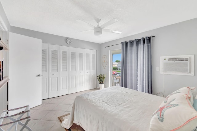 tiled bedroom with a wall unit AC, a textured ceiling, a closet, and ceiling fan