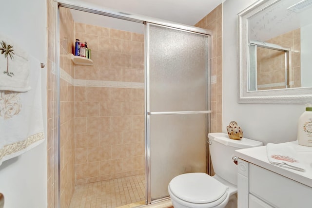 bathroom featuring a shower with door, vanity, and toilet