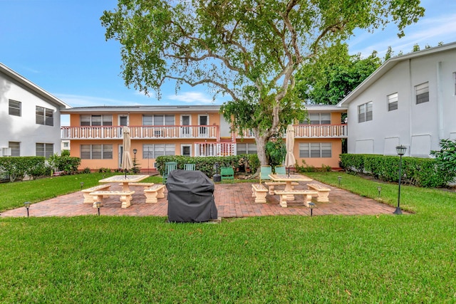 surrounding community featuring a patio area, a lawn, and a fire pit