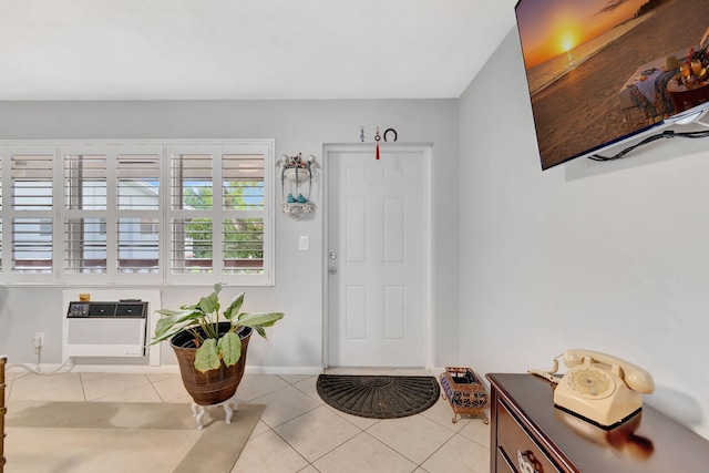 foyer with a wall unit AC and light tile patterned floors