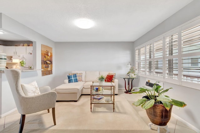 living room featuring a textured ceiling and light tile patterned floors