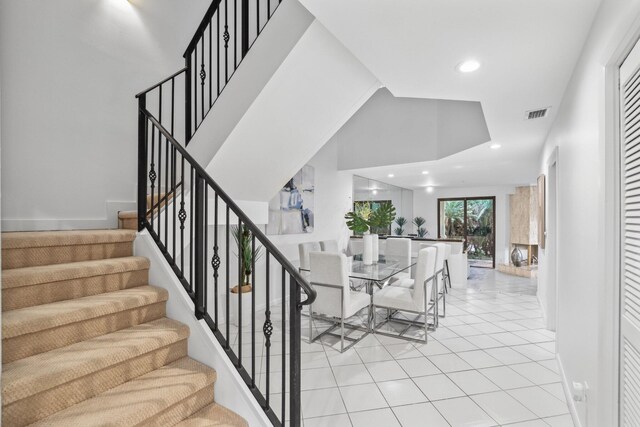 tiled dining space featuring a towering ceiling