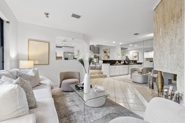 kitchen featuring decorative backsplash, white cabinets, sink, ceiling fan, and a breakfast bar area