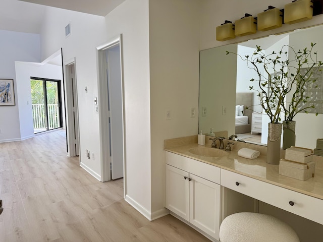 bathroom featuring visible vents, baseboards, wood finished floors, and vanity