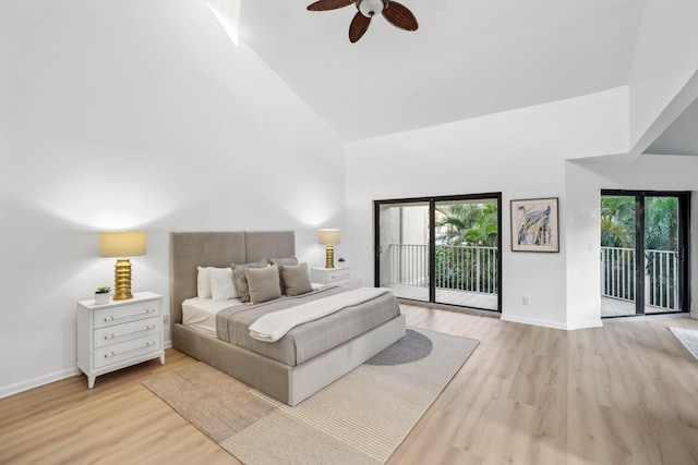 bedroom with access to exterior, light wood-type flooring, and high vaulted ceiling