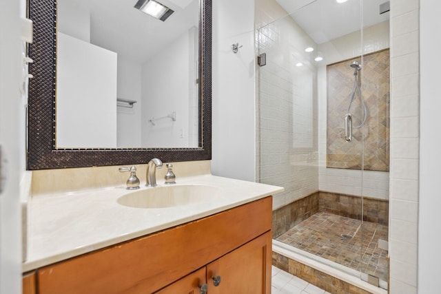 bathroom with a shower with door, tile patterned floors, and vanity