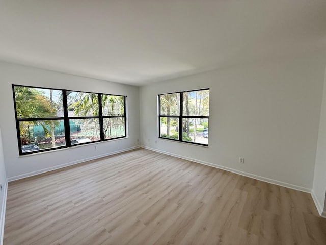 unfurnished room featuring light wood-type flooring and baseboards