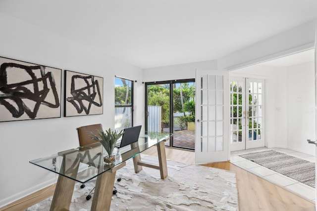 office space with plenty of natural light, hardwood / wood-style floors, and french doors