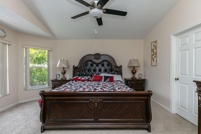 carpeted bedroom featuring ceiling fan, a textured ceiling, and vaulted ceiling