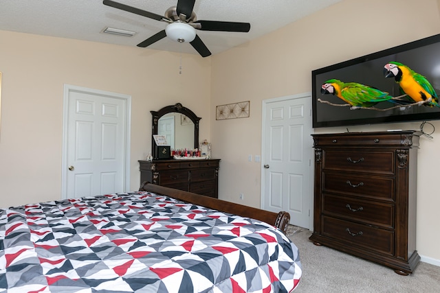 carpeted bedroom featuring a textured ceiling and ceiling fan