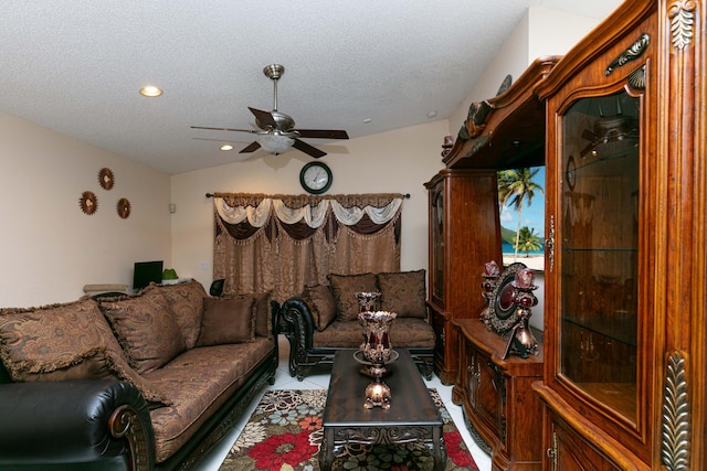 living room featuring ceiling fan, tile patterned floors, a textured ceiling, and vaulted ceiling