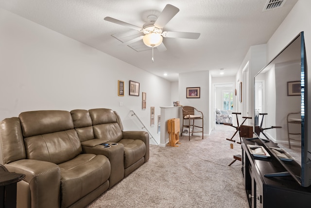 living room with ceiling fan, light carpet, and a textured ceiling