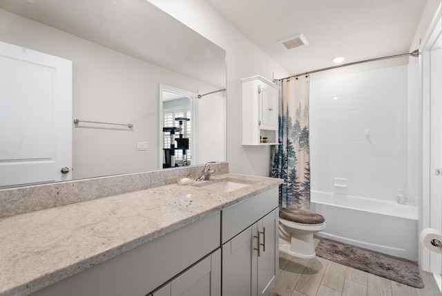 full bathroom with hardwood / wood-style floors, shower / bath combo, toilet, and vanity