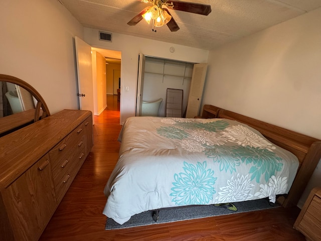 bedroom featuring a textured ceiling, ceiling fan, a closet, and dark hardwood / wood-style floors