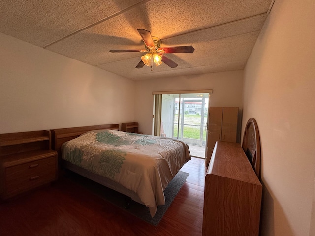 bedroom with a textured ceiling, access to outside, ceiling fan, and dark wood-type flooring