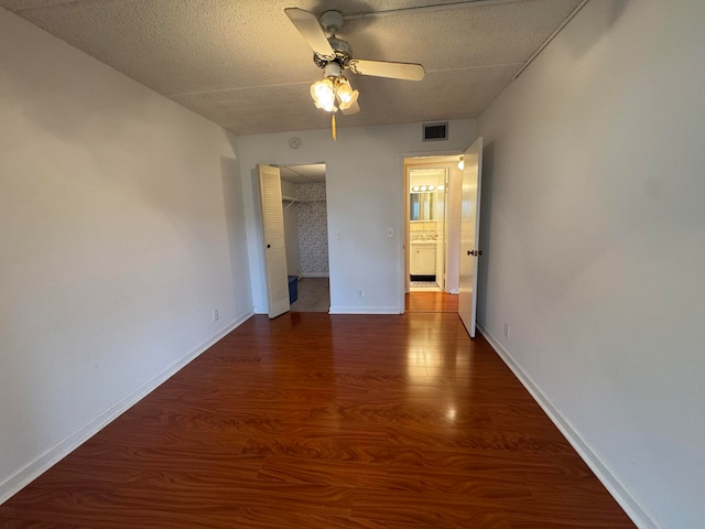 empty room featuring ceiling fan and dark wood-type flooring