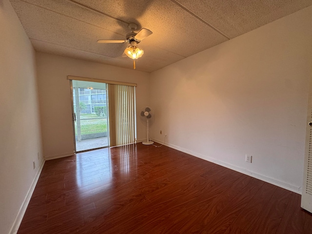 empty room featuring ceiling fan and dark wood-type flooring