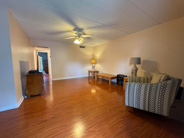 living room with ceiling fan, wood-type flooring, and a textured ceiling